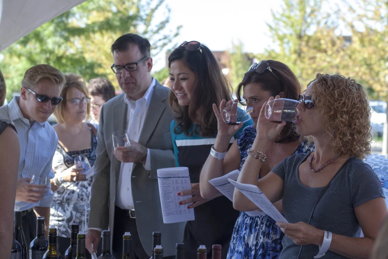 a group of people look at several bottles