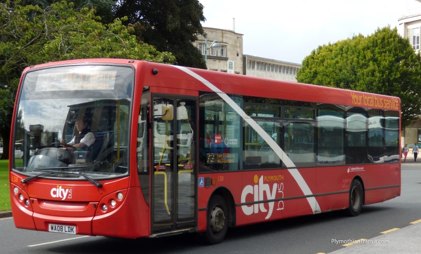 a red city bus traveling down a road