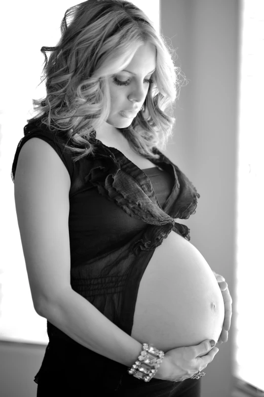 an attractive pregnant woman posing for a po in her lacy clothing