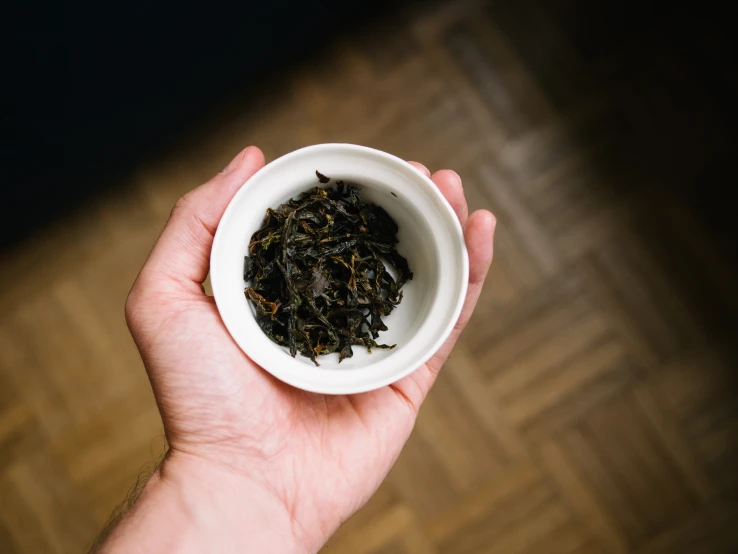 a man holding a cup of black tea