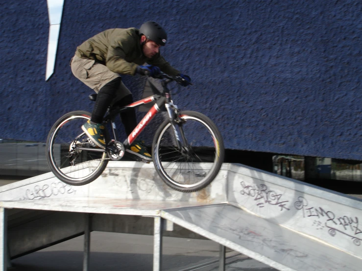 man performing tricks on bike using metal railing