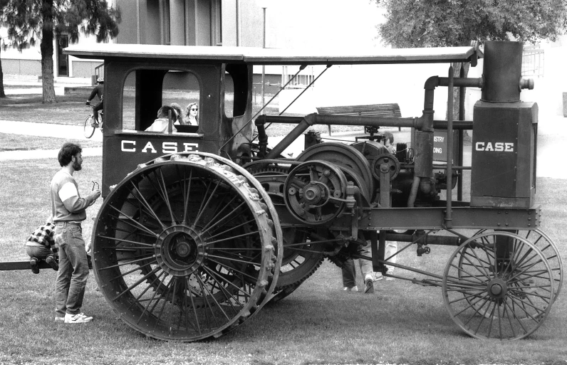 a man standing next to an old antique engine