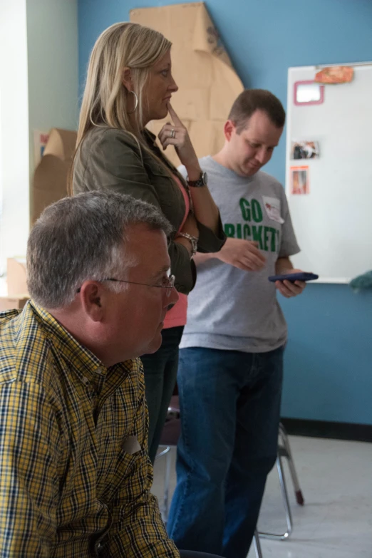 a woman and two men working on soing with the help of the two other men