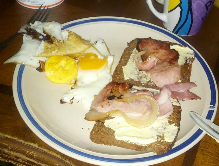 a white plate with an egg, ham, and toast on it