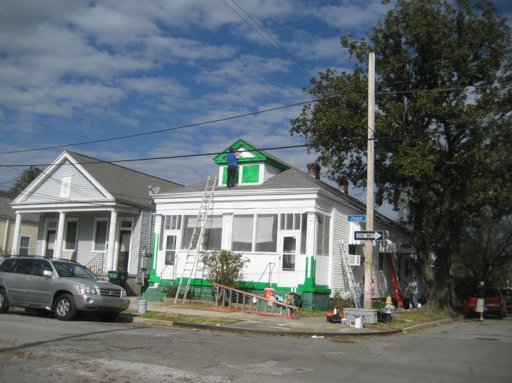 this house is painted green and white with an arched window