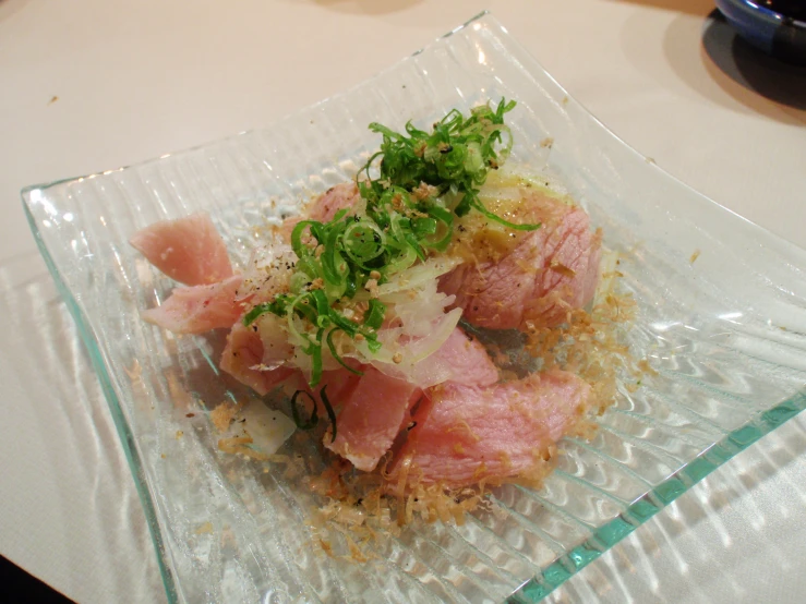 a square glass plate with food sitting on a table