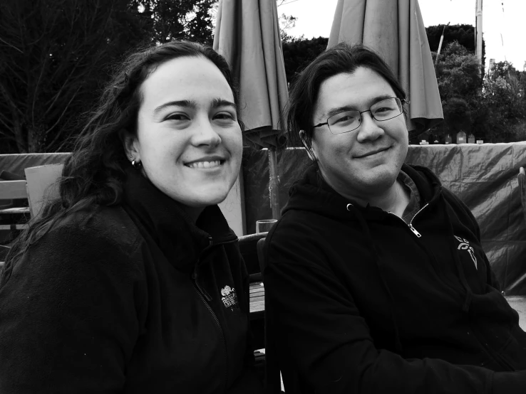 a woman sitting next to a man with long brown hair