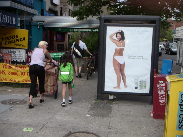 an advertit on a busy sidewalk advertising a female in her underwear