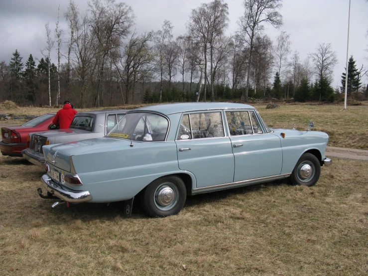 old cars are parked side by side in a field