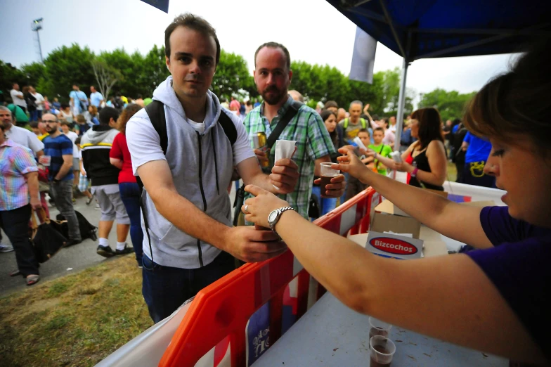 a man holding up a drink to another person