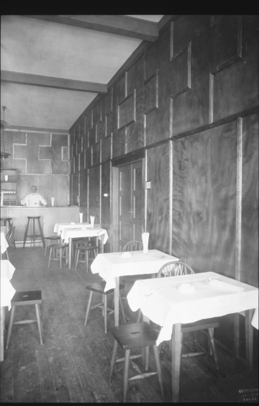 a vintage po of an old dining room with chairs and tables