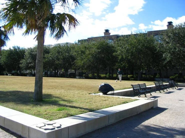 a person with an umbrella walking towards a group of benches