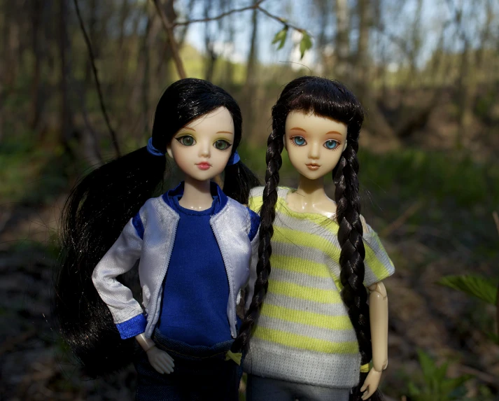 two dolls wearing long, ids standing next to each other