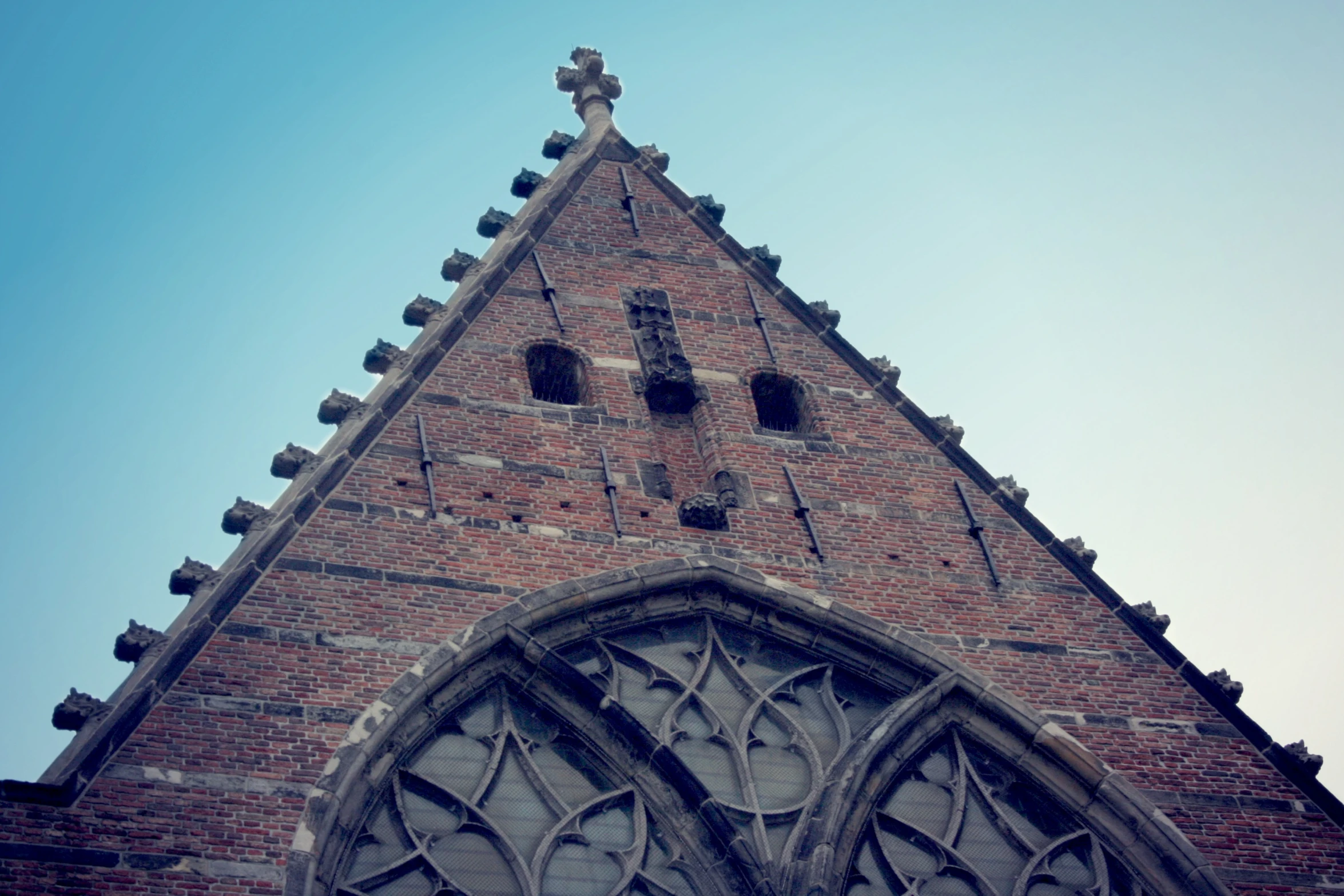 a stone cathedral with windows that have a cross on them