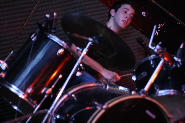 a man holding drums behind him on stage