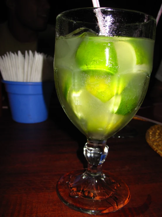 a glass of green liquid on top of a table