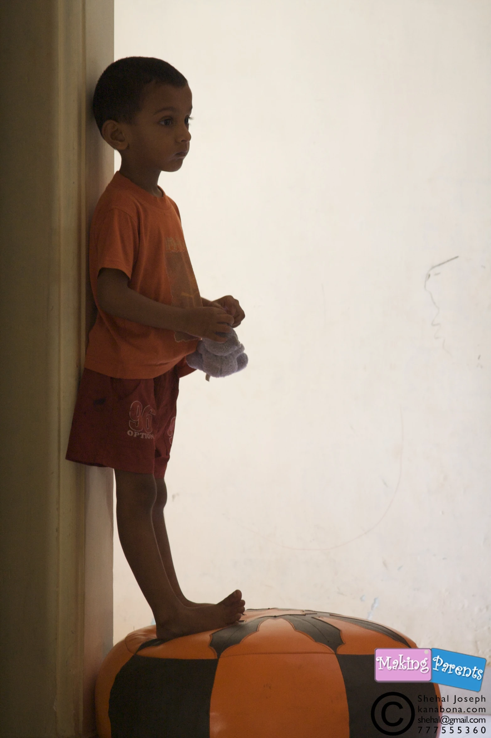 a child standing on top of an orange and black striped object