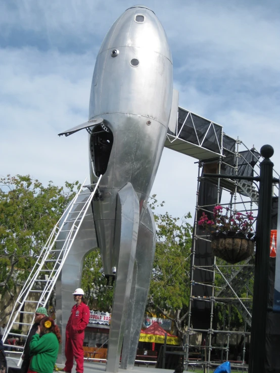 some people standing around a large metal object