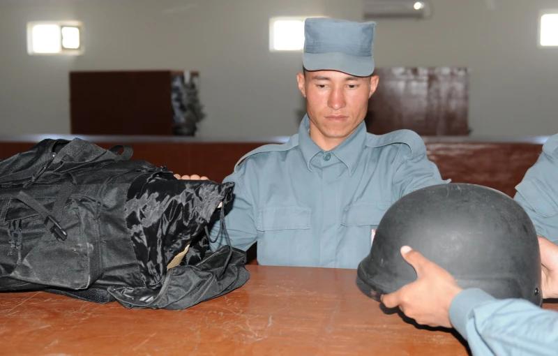 two uniformed officers are examining uniforms in a building