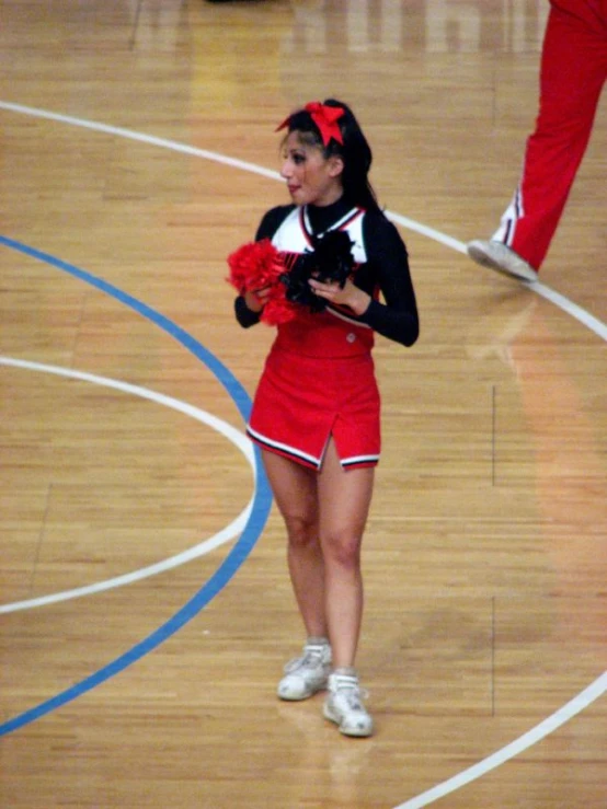 a young lady in a cheerleader uniform on the court