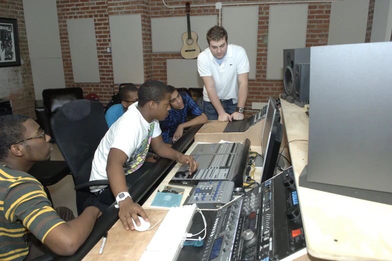 a group of men working at a computer together