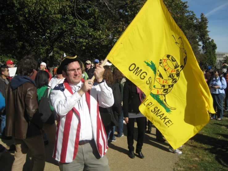 people in costume are standing outside while the man holds a flag