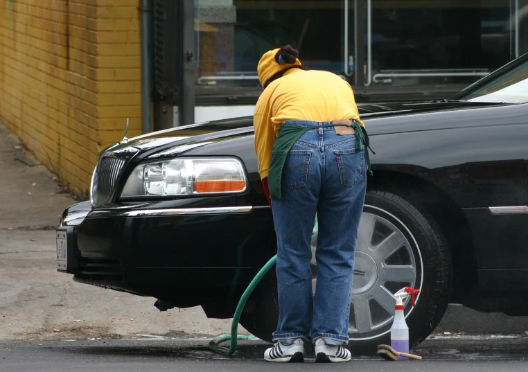 a person washing a car with a hose