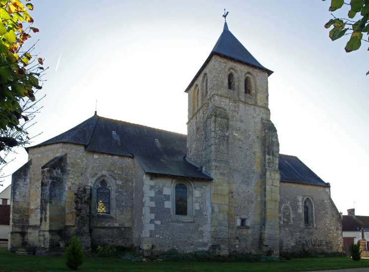 a large brick church with a steeple, set in the sun