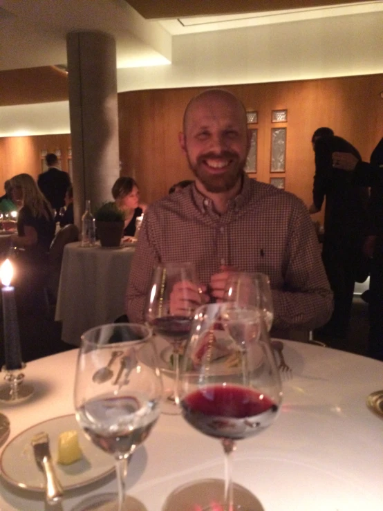 a man sitting at a table in front of some glasses