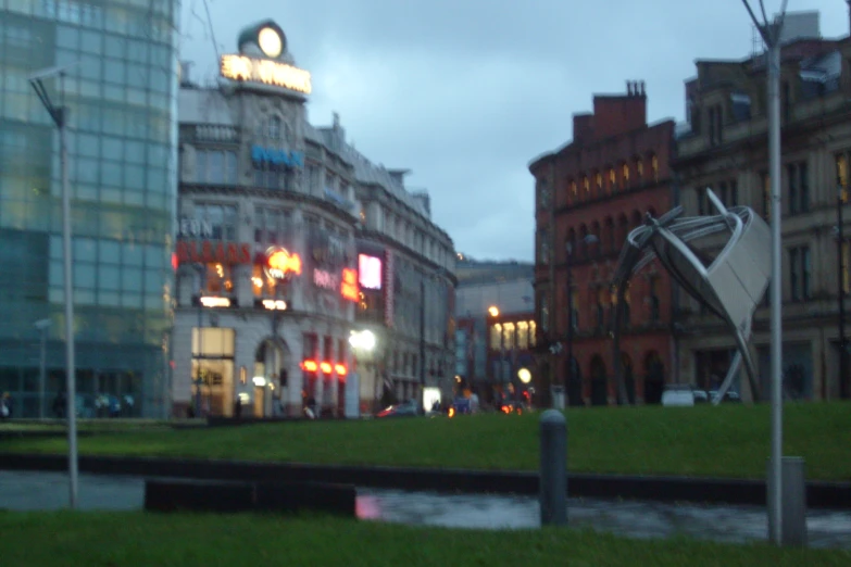 street lights with a statue near it in the middle of a grassy area