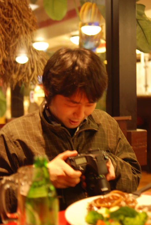 a person that is holding a camera on a table