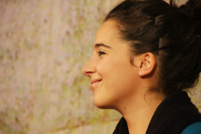 a woman smiling wearing a ponytail in a ponytail