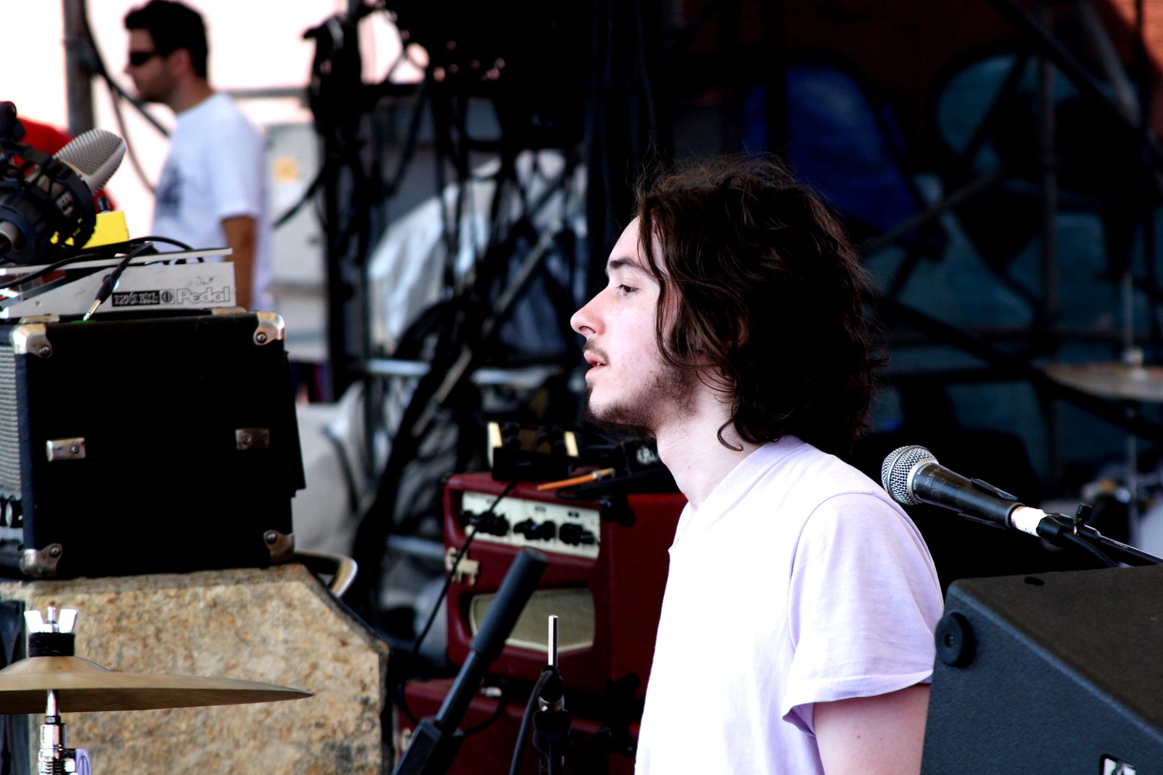 a man is singing on stage at an outdoor event