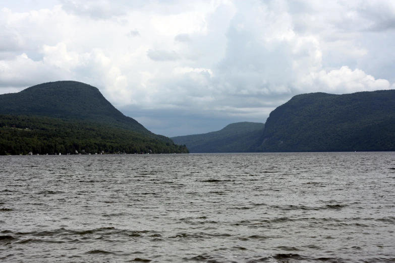 there are several mountains in the distance, on water