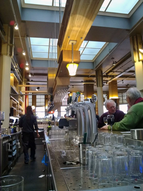 a man is sitting at a bar in an open space