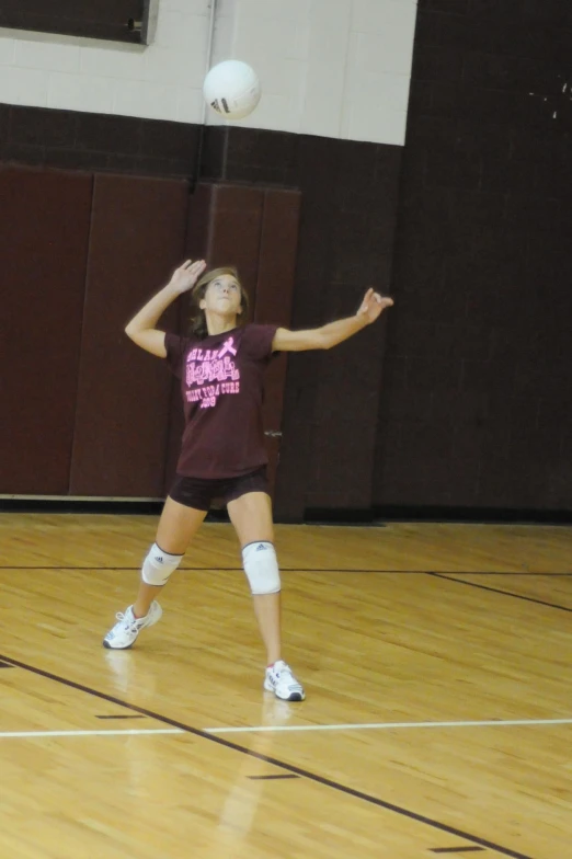 a woman is playing frisbee in a gymnasium