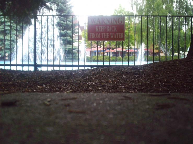 an iron gate and a sign in front of a park