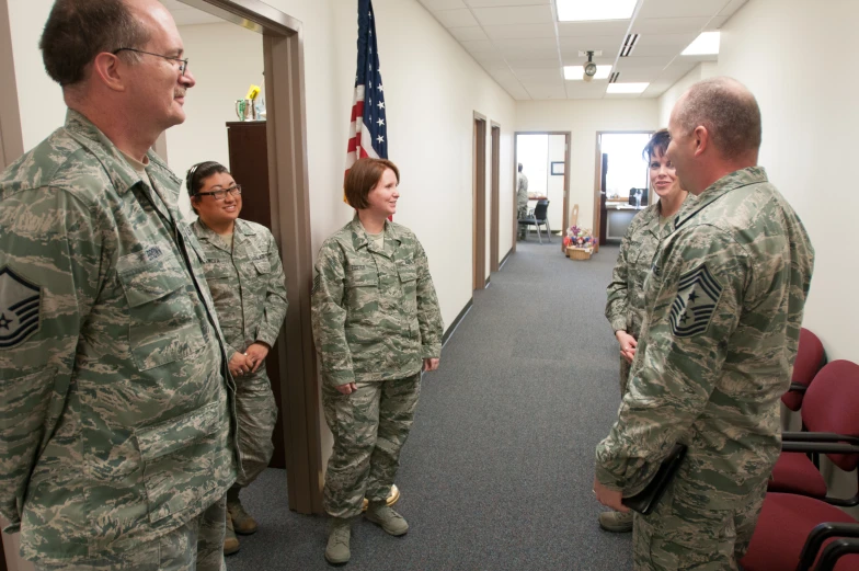 a group of military people in uniform talking to each other