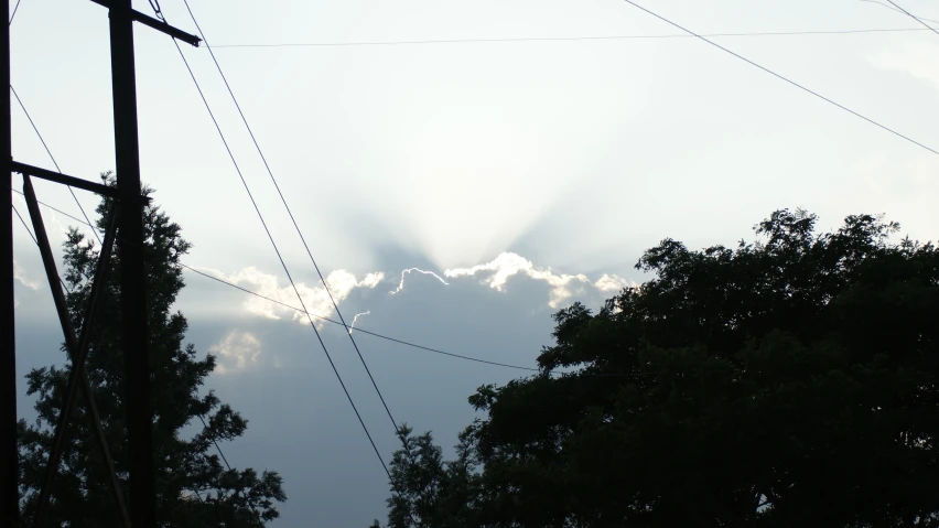 some power lines and the sky are partly obscured by the sun