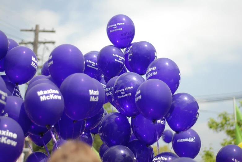 a large group of purple balloons is in the air