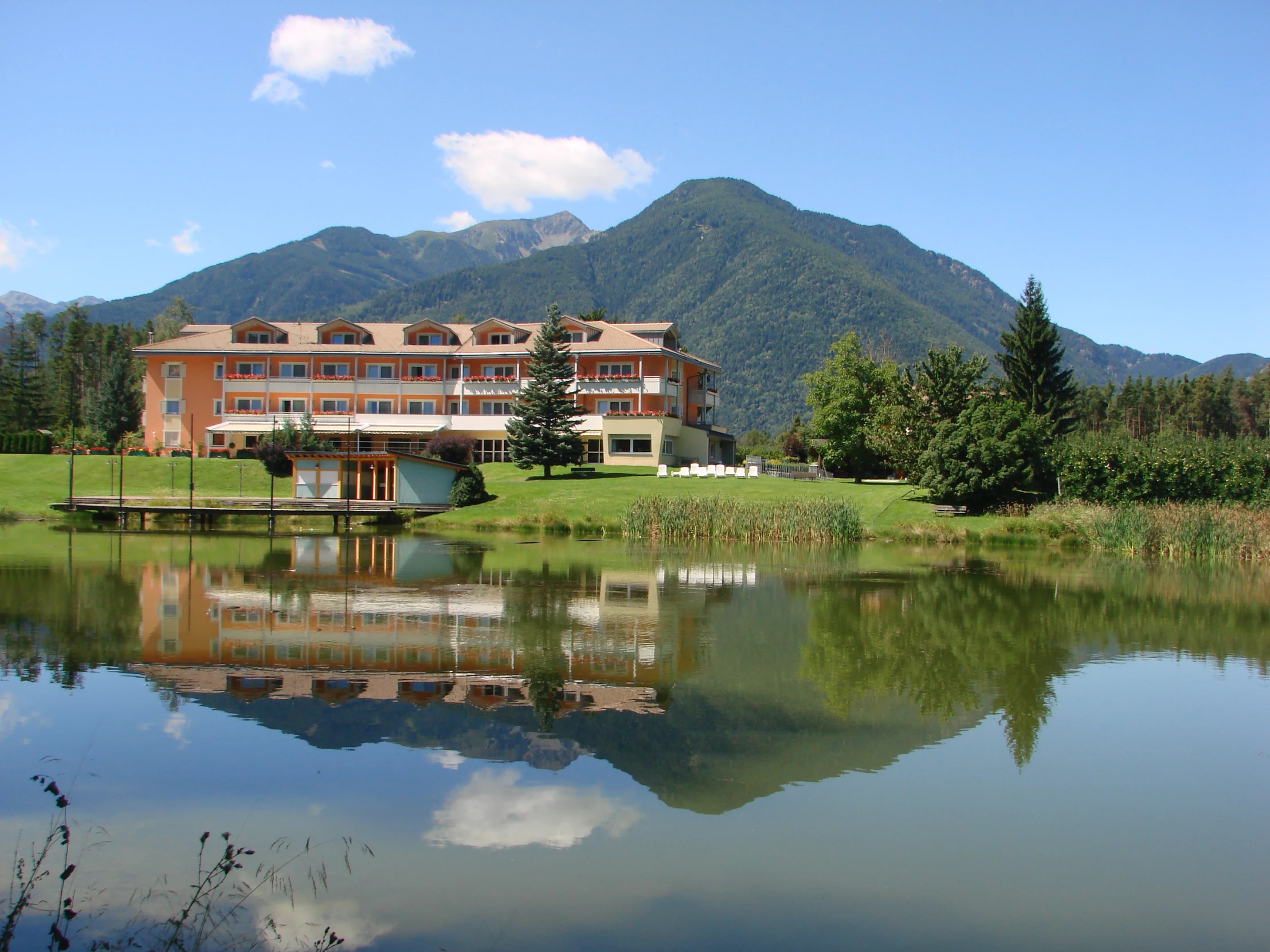 the mansion with mountains in the background is on a lake