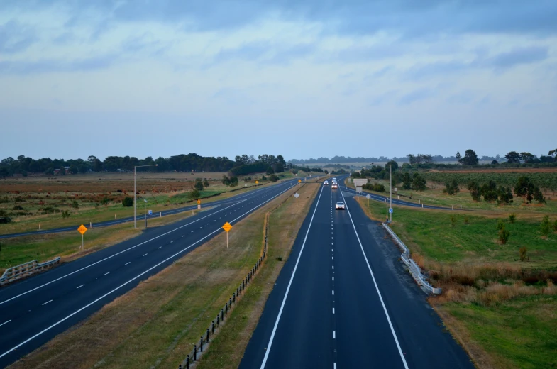 a highway runs parallel to a grassy field