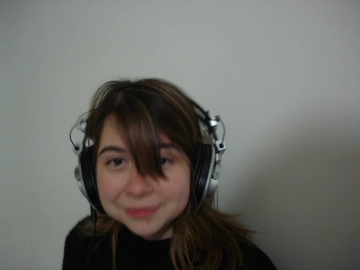 a girl wearing some headphones with her eyes closed