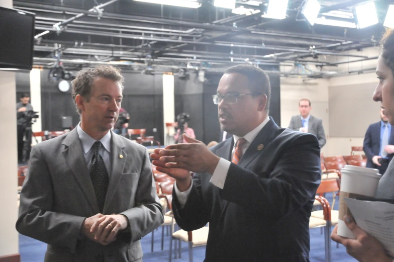 two men in suits standing and talking to each other