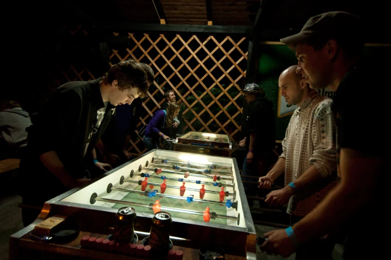 a group of people standing around a wooden table