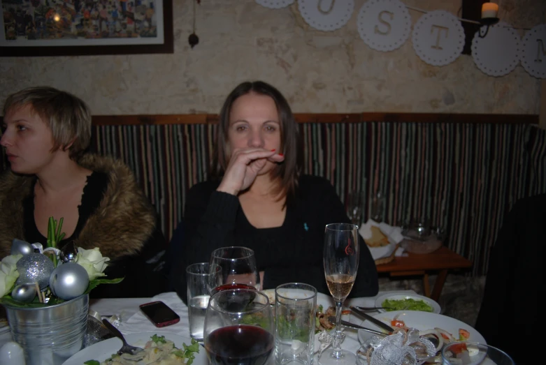 two women sitting at a dinner table eating