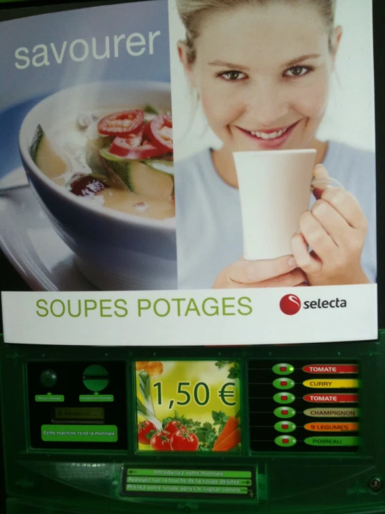 a woman holding a cup in front of a vending machine