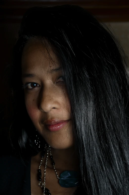 a woman with black hair, wearing jewelry