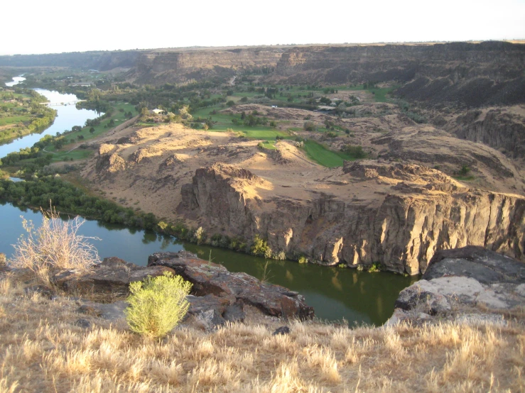 a valley overlooking an island and lake with large rocks