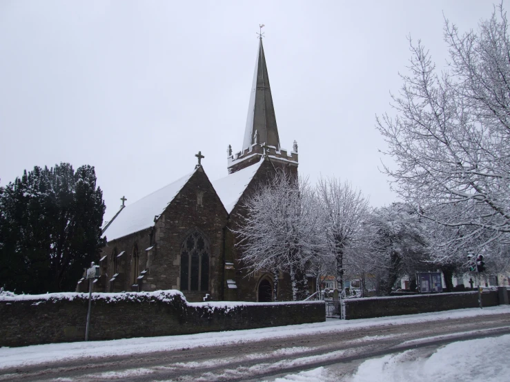 a snow covered church is surrounded by trees